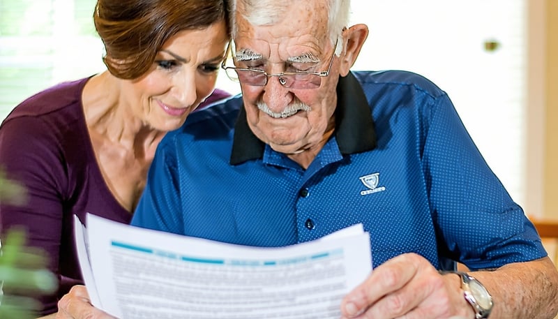 A caregiver assisting a veteran with paperwork, sy